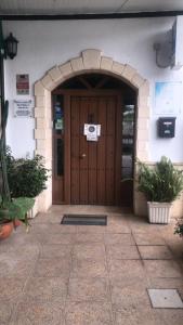 una entrada a un edificio con puerta de madera en Hostal Andalucia, en Arcos de la Frontera