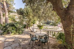 a patio with a table and chairs under a tree at Villa Prestige '50 in Capri