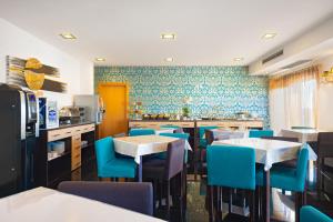a restaurant with tables and blue chairs in a kitchen at Hotel DAH - Dom Afonso Henriques in Lisbon