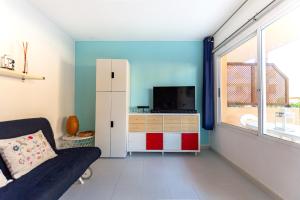 a living room with a couch and a tv at BeachApartment in Corralejo
