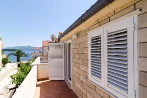 a balcony with white shutters on a building at Holiday Home Jasenka Trstenik in Trstenik