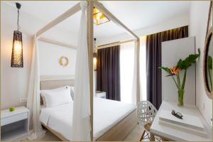 a bedroom with a white bed and a mirror at TEREZAS HOTEL in Sidari