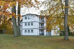 a white house with trees in front of it at Villen am Buchenpark 08 in Heringsdorf