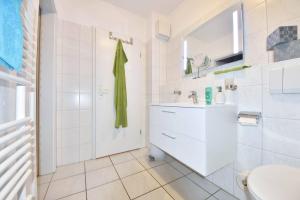 a white bathroom with a sink and a toilet at Villen am Buchenpark 08 in Heringsdorf