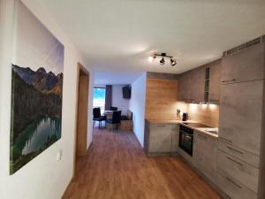 a kitchen with wooden cabinets and a dining room at Appartement Bergfuier in Holzgau