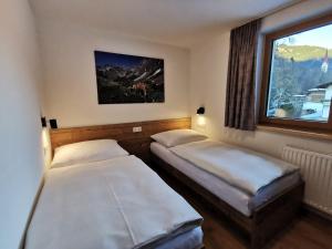 two beds in a room with a window at Appartement Bergfuier in Holzgau