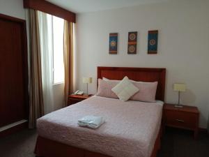 ZamoraにあるHotel Samuriaのベッドルーム1室(ベッド1台、テーブル2台、ランプ2つ付)