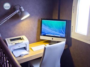 a computer desk with a monitor, keyboard and mouse at Hotel La Chancla in Málaga