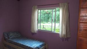 a bedroom with a window and a bed in it at Susurro de Montaña (TIERRA SANTA) in San Lorenzo +13 photos