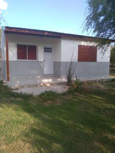 a small white house with a garage at Susurro de Montaña (TIERRA SANTA) in San Lorenzo