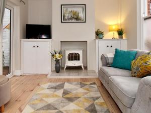 uma sala de estar com um sofá e uma lareira em A Character Cottage in Historical Canterbury em Canterbury