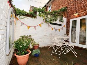 a patio with a table and chairs and plants at A Character Cottage in Historical Canterbury in Canterbury