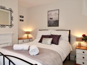 ein Schlafzimmer mit einem großen weißen Bett und Kissen in der Unterkunft A Character Cottage in Historical Canterbury in Canterbury