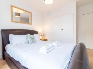 a bedroom with a large white bed with a mirror at Bright and Cosy Flat at the Heart of the Old Town in Edinburgh