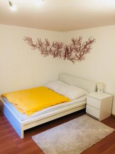 1 dormitorio con 1 cama con una pintura en la pared en ruhiges privates Zimmer in Freiburg, zentrumsnah, Nähe Europapark, en Freiburg im Breisgau