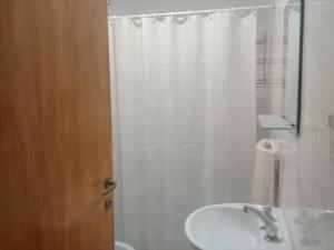 a white bathroom with a sink and a shower at DptosECONOMICOS1 in Necochea
