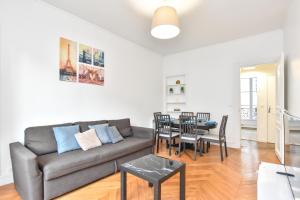 een woonkamer met een bank en een tafel bij CMG Résidence Réaumur in Parijs