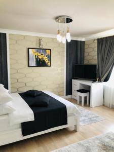 a bedroom with a white bed and a television at The Classic Studio in Buzău