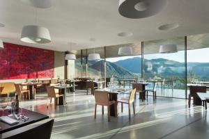 a restaurant with tables and chairs and a view of mountains at Vik Chile in San Vicente de Taguatagua