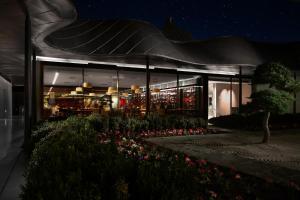 um edifício com flores à frente à noite em Vik Chile em San Vicente de Taguatagua