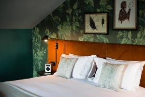 a bedroom with a large bed with white pillows at Hotel Du Vin Stratford in Stratford-upon-Avon