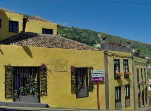a building with a sign on the side of it at Apartamentos Monasterio de San Antonio in Icod de los Vinos