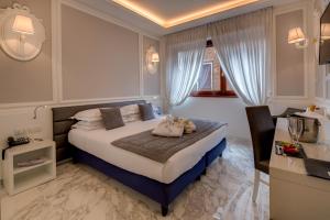 Una habitación de hotel con una cama y un escritorio y un escritorio. en Grande Albergo Roma, en Piacenza