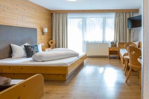 ein Hotelzimmer mit einem Bett, einem Schreibtisch und einem Zimmer in der Unterkunft Ferienhof Schöne Aussicht in Pfunds
