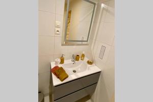 uma casa de banho branca com um lavatório e um espelho em Cocon de Douceur : Apaisement et Harmonie intérieure em Blois