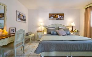 
a hotel room with a bed, desk, chair and lamp at Agrimia Holiday Apartments in Platanias
