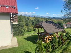 a gazebo in a yard next to a building at MonteCrai in Şirnea