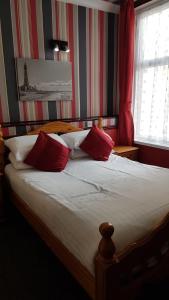 ブラックプールにあるValdene Hotelのベッドルーム1室(赤と白の枕付)