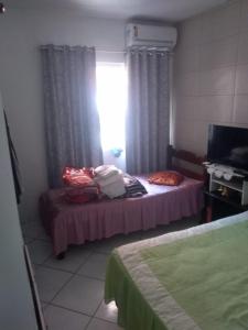 Habitación con cama y ventana con cortinas. en Casa 8 pessoas 20m do mar 004, en Florianópolis