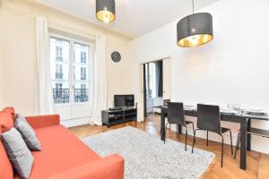 een woonkamer met een bank en een eetkamer bij CMG Résidence Réaumur in Parijs