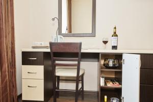 a kitchen with a desk with a chair and a bottle of wine at Hotel Chalpan in Abakan
