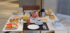 a breakfast table with plates of food on it at Lets Idea Brasília Hotel in Brasilia