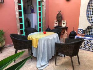 een tafel in een kamer met stoelen en een tafel met bij Dar Dayana in Essaouira