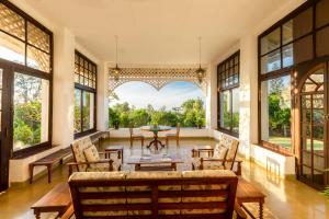 an empty living room with a large window and a table at Ama Plantation Trails Coorg in Gonikoppal