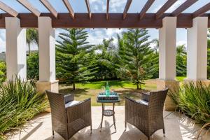 a patio with a table and chairs under a pergola at Stunning Villa with Private Pool and Jacuzzi in Casa de Campo in La Romana