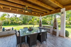 a patio with a table with chairs and a ceiling fan at Stunning Villa with Private Pool and Jacuzzi in Casa de Campo in La Romana