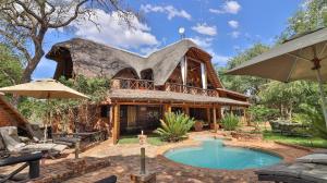 a large house with a pool in front of it at Kruger Riverside Lodge - No Load-shedding in Marloth Park