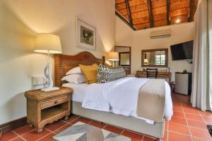 a bedroom with a bed and a table and a television at Kruger Private Lodge in Marloth Park