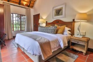 A bed or beds in a room at Kruger Private Lodge