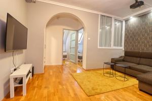 een woonkamer met een bank en een tv bij CinemApartman Eger in Eger