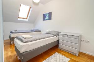 een slaapkamer met 2 aparte bedden en een dressoir bij CinemApartman Eger in Eger