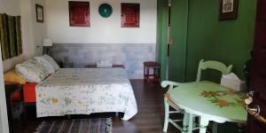 a bedroom with a bed and a table and chairs at La Escuela del Campo in Setenil