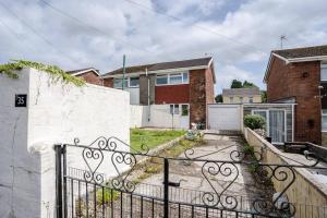 a home with an iron gate in a yard at Sleep at The Twyn - TV in Every Bedroom! in Swansea