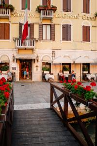 a building with a bridge and flowers in front of it at Hotel Carlton On The Grand Canal in Venice