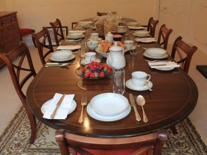 a wooden table with plates and utensils on it at Church Farmhouse B & B in Kennett
