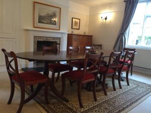 a dining room with a wooden table and chairs at Church Farmhouse B & B in Kennett